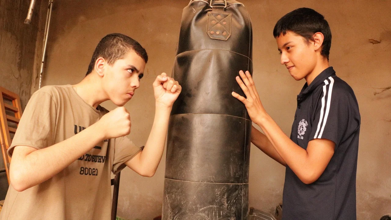 Adolescente recebe orientação para usar equipamento de musculação.