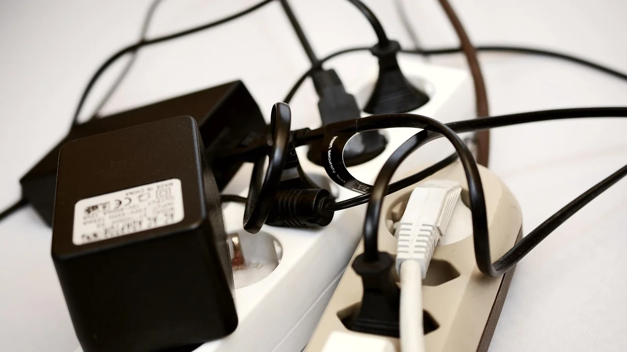 Eletricista analisa a fiação de um quadro de distribuição.