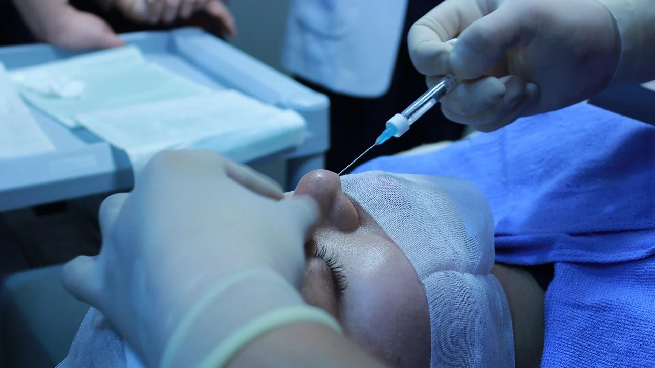 Profissional prepara materiais para procedimento estético injetável.