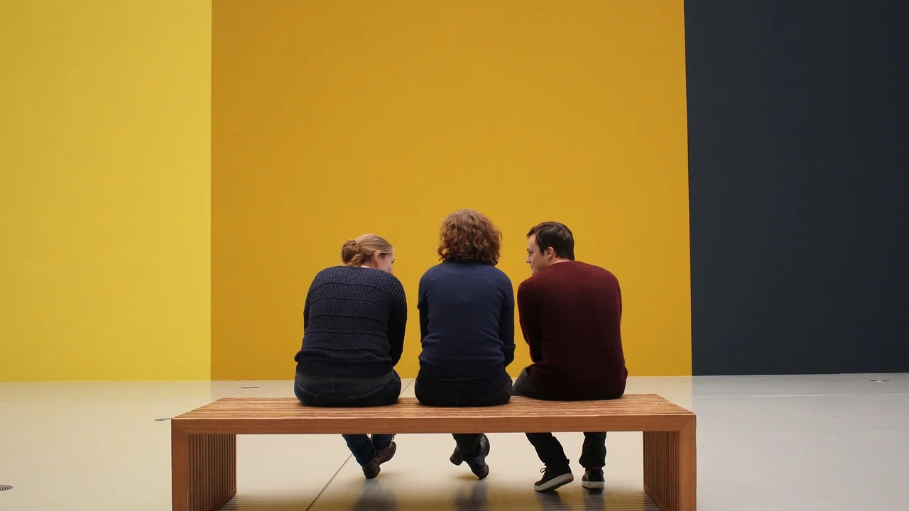 Visitantes observam obras em uma galeria de arte.