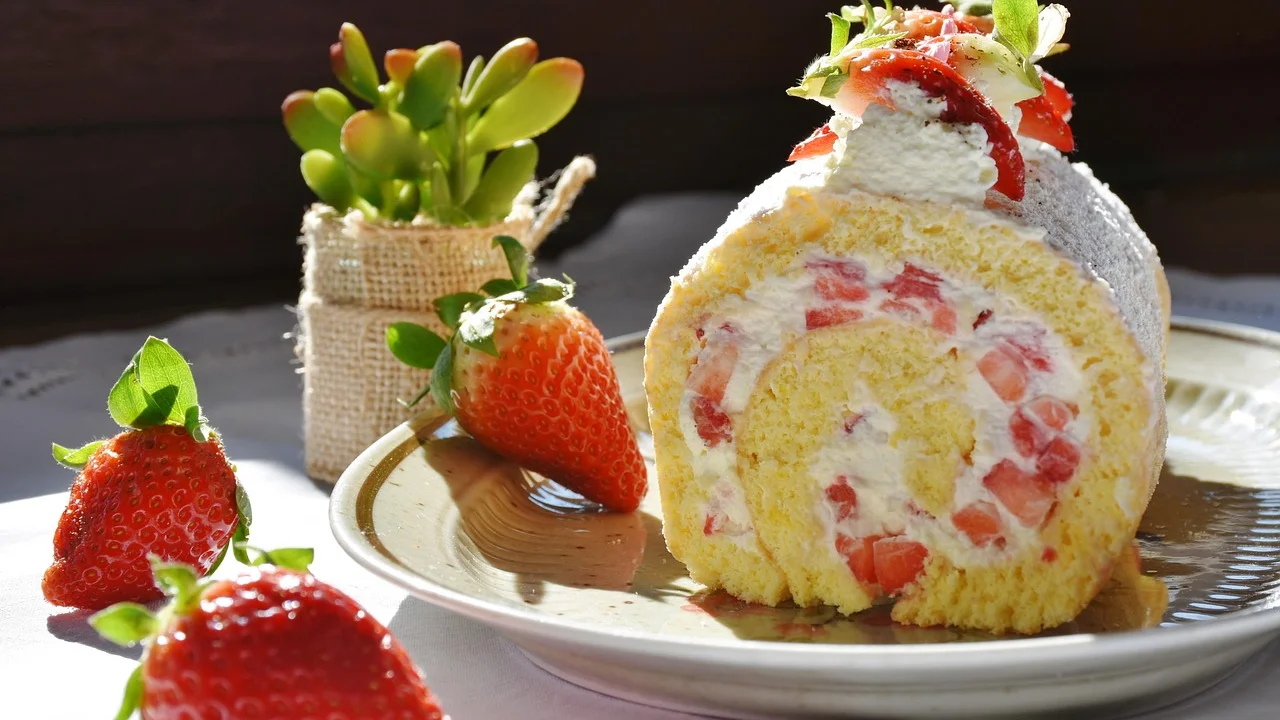Bolo de morango decorado com frutas frescas sobre cobertura cremosa.