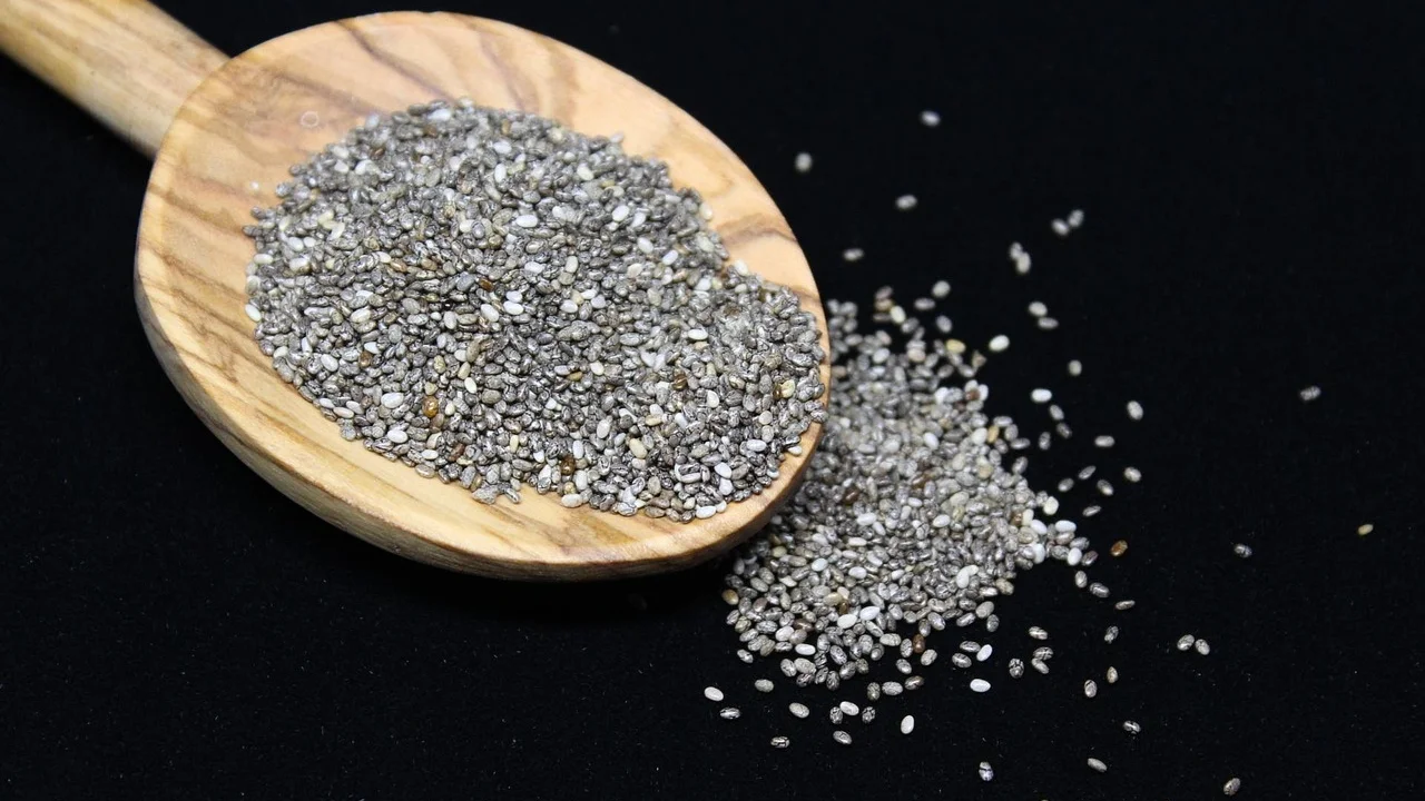 Sementes de chia em colher de madeira sobre fundo claro