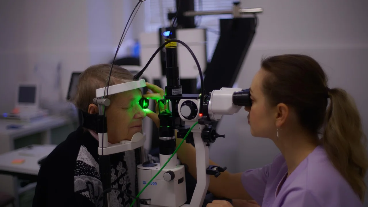 Oftalmologista observa estruturas oculares com equipamento clínico.