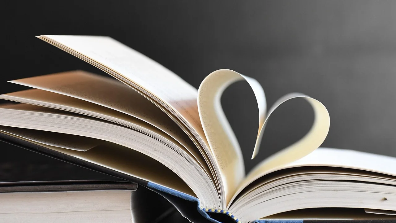 Caderno, canetas e livros usados na elaboração de um trabalho.