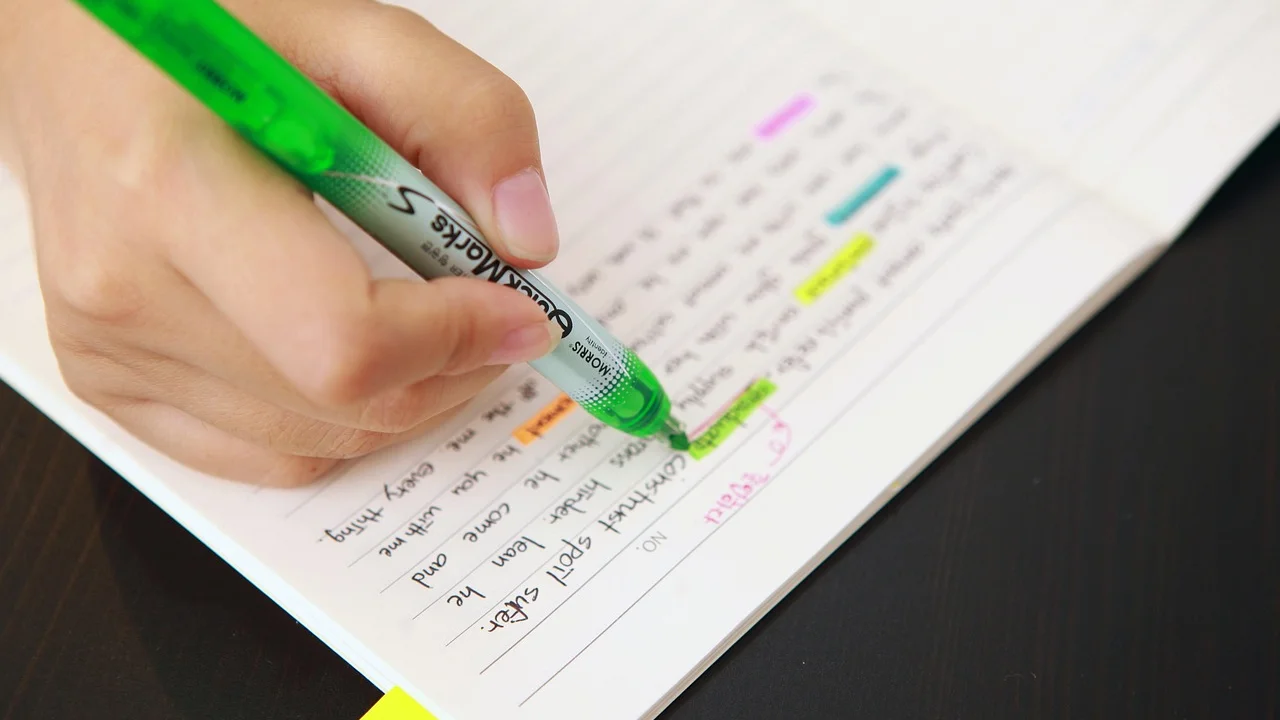 Estudante organiza anotações de leitura em caderno.