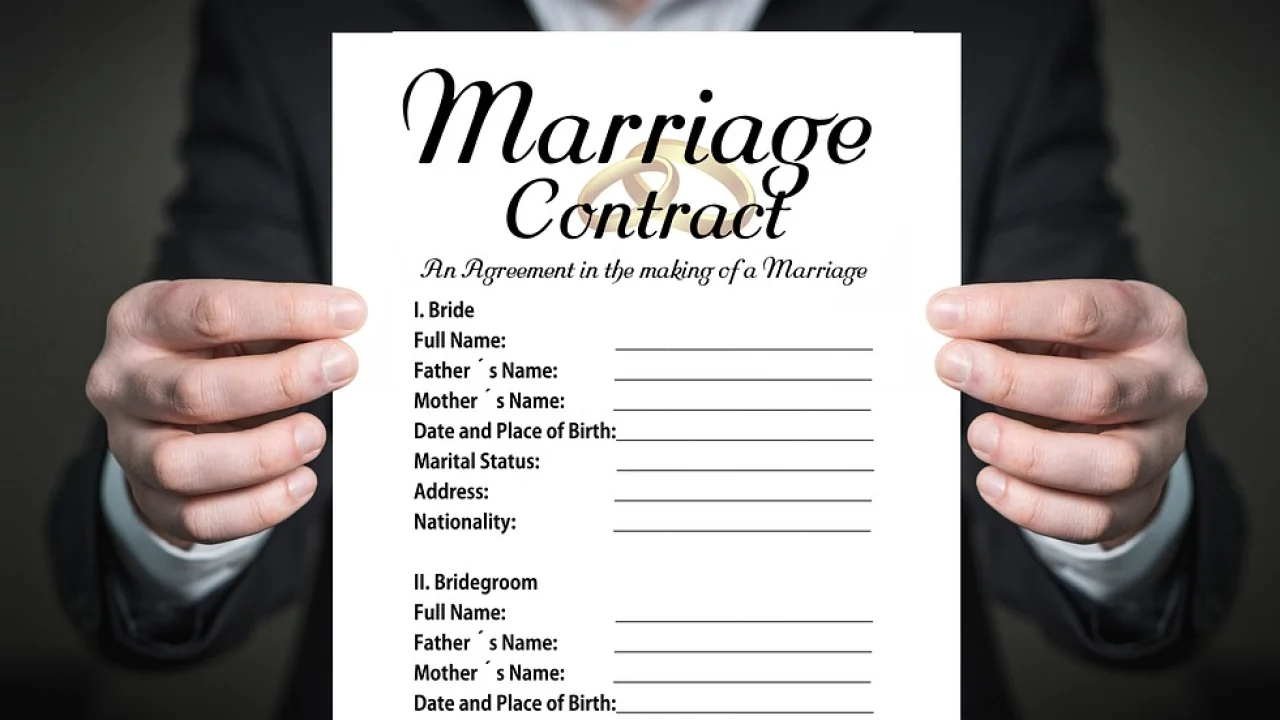 Certidão de casamento sobre uma mesa com documentos pessoais.