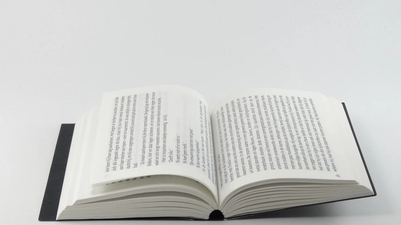 Pessoa escrevendo versos em um caderno sobre a mesa.