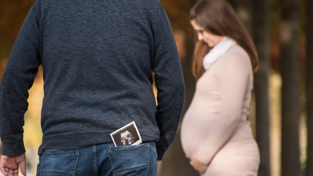 Gestante conversa com obstetra durante consulta de pré-natal.