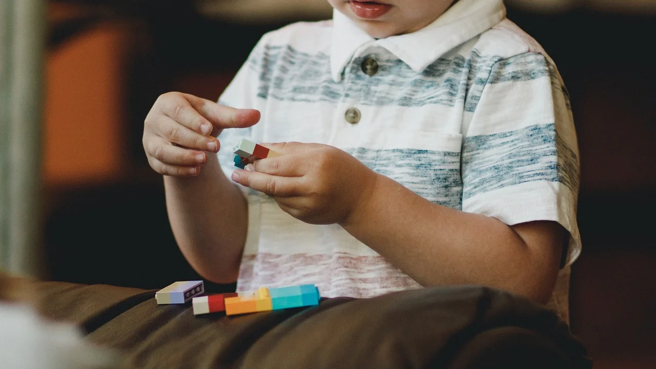 Mãos infantis encaixando peças de brinquedo