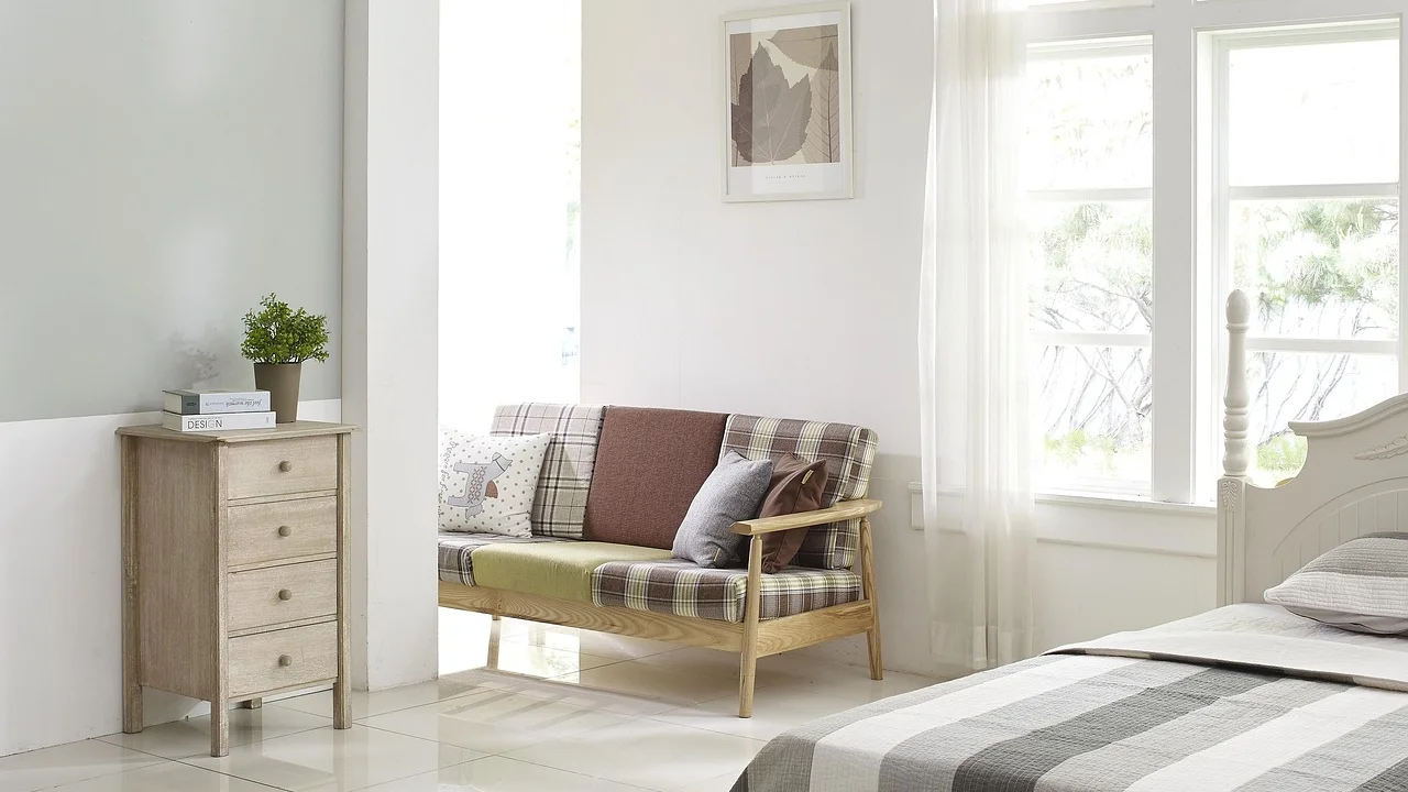 Cama queen com roupa de cama em tom neutro