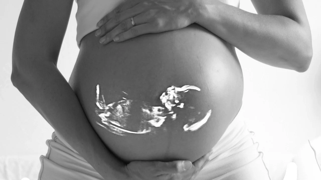 Médica explica resultados da biometria fetal à gestante.