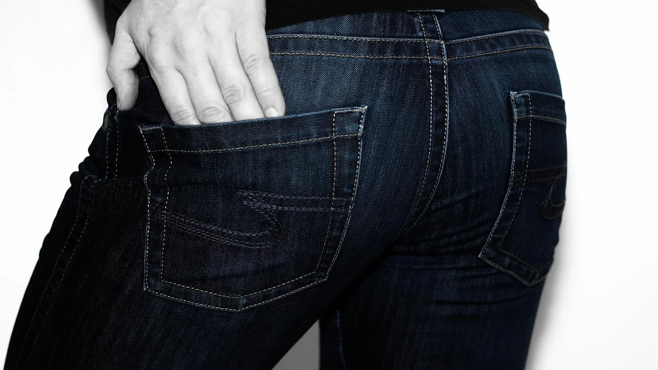 Medição da entreperna de uma calça sobre superfície plana.