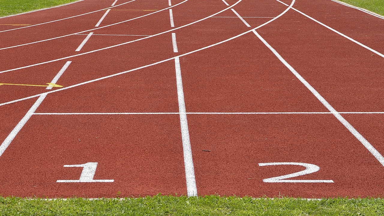 Corredora realiza treino em pista ao ar livre.