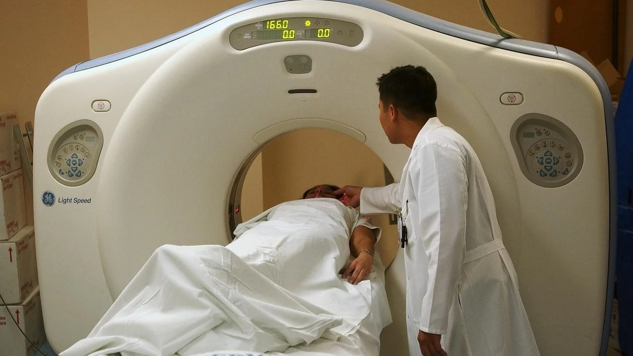 Paciente posicionado em maca para realização de exame de tomografia.